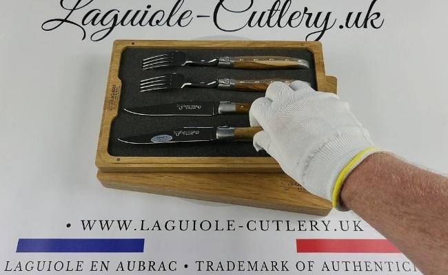 Two Laguiole steak knives and two forks with pistachio wood handles